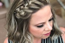 a cool half updo with a large braid from the center to the side and waves down is a catchy and cool hair idea
