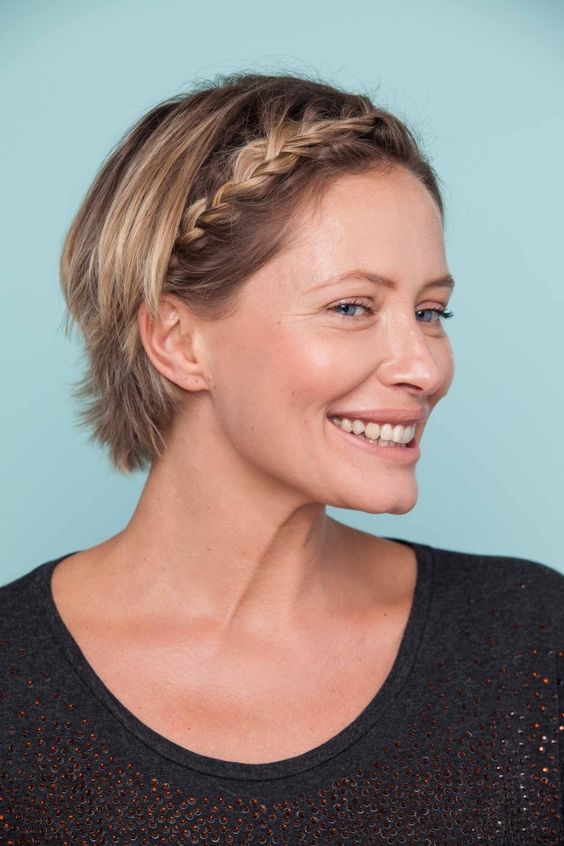 a layered short bob with a single braid starting in the center and going to the side of the head