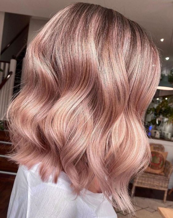 a long strawberry blonde bob with waves and a darker root is a stylish and cool idea for any time