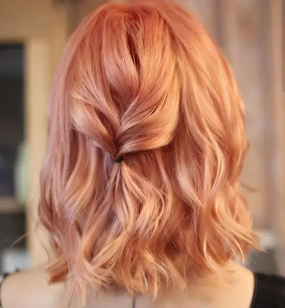 a long strawberry blonde bob with waves and a ponytail is a lovely and chic idea for anyone