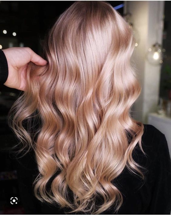 long wavy hair in a soft and light strawberry blonde shade is a cool and chic idea for a delicate look