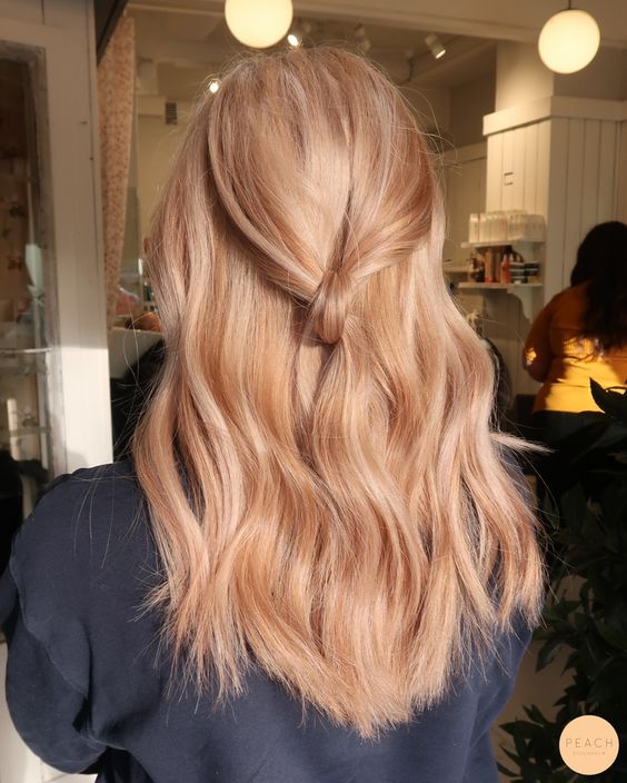 long wavy strawberry blonde hair with some volume and a knot is a chic and stylish solution if you like such shades