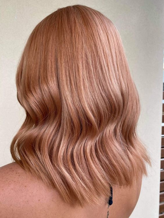 medium-length strawberry blonde hair with a bit of waves is perfect if you like warmer shades of pink