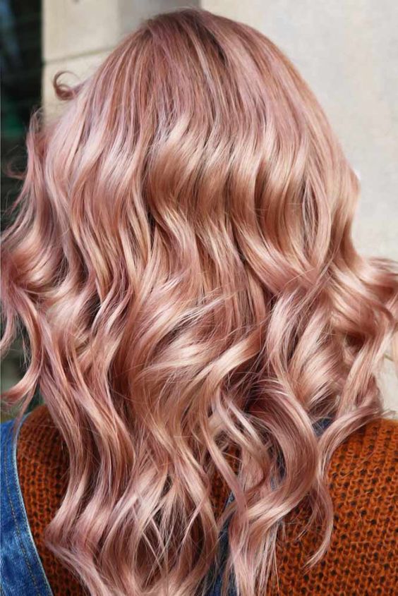 messy wavy long strawberry blonde hair with some volume is a very cool and catchy idea to rock