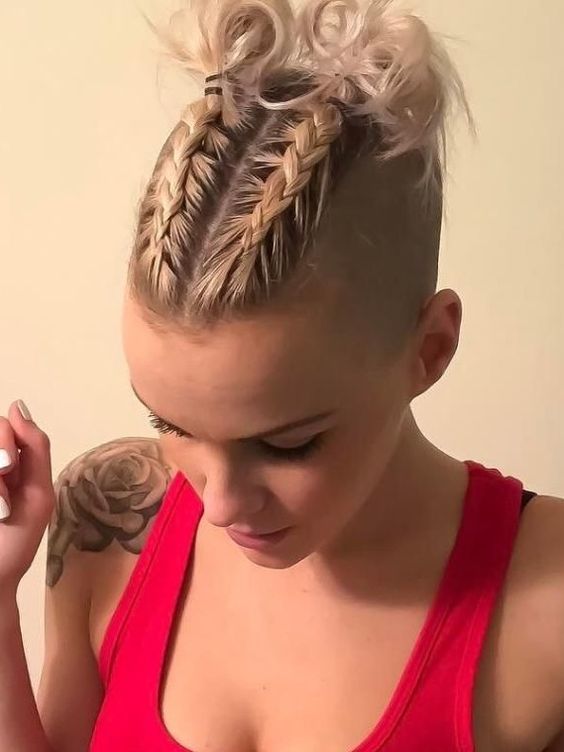 short blonde hair styled with two braids on top and little curly buns at the ends is a creative hairstyle