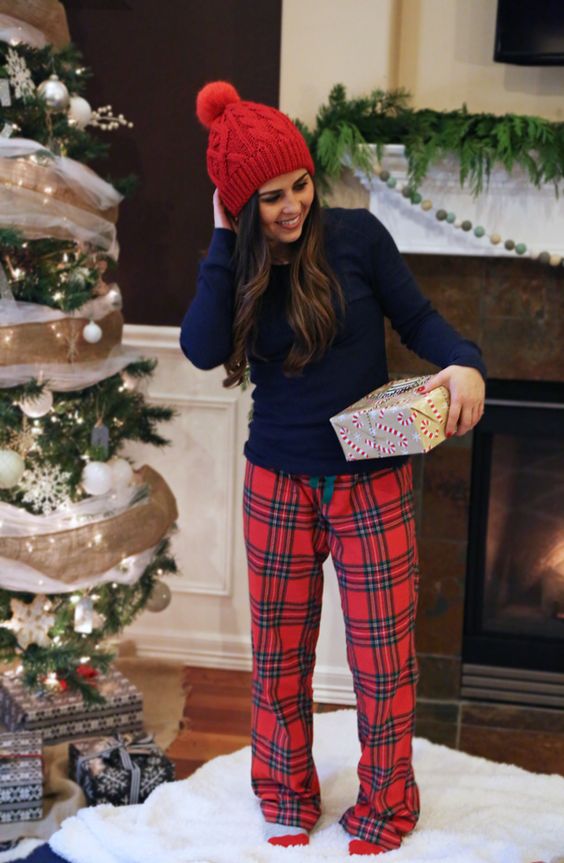 a navy long sleeve top, erd plaid pants, a red beanie for a cozy Christmas morning look
