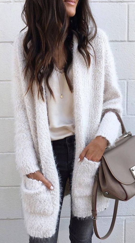 a black skinnies, a neutral top with lace, a fluffy creamy cardigan and a taupe bag