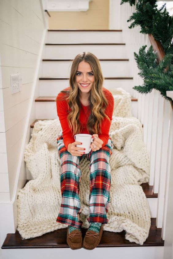 a red sweater, plaid pants, moccasins and a white chunky knit blanket for maximal comfort