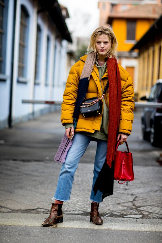 cropped jeans, chelsea boots, an olve green hoodie, a bold yellow puffed coat, a red bag