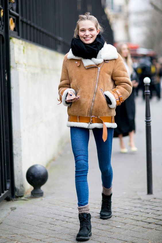 blue skinnies, an orange shearlign coat, a black scarf and black combat boots for a cozy winter outfit