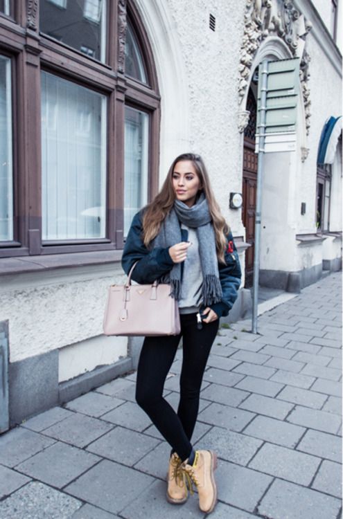 tan combat boots, black skinnies, a grey sweater, a black puffed coat and a blush bag