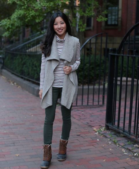 With gray vest, green pants and lace up boots