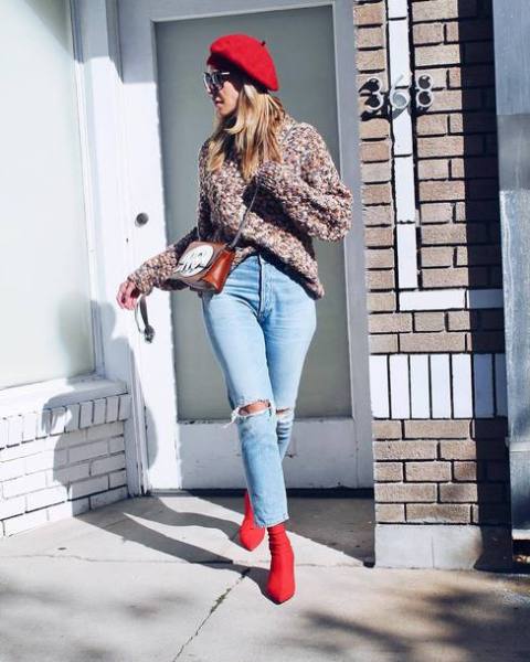 With loose sweater, distressed jeans, chain strap bag and red sock boots