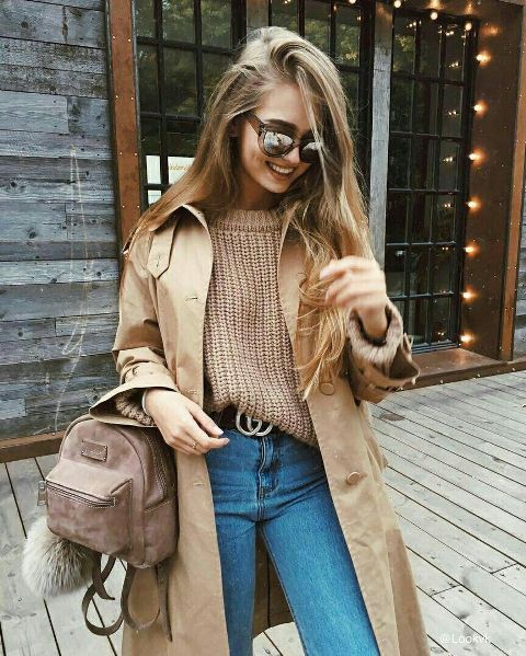 With loose sweater, trench coat, high-waisted jeans and belt
