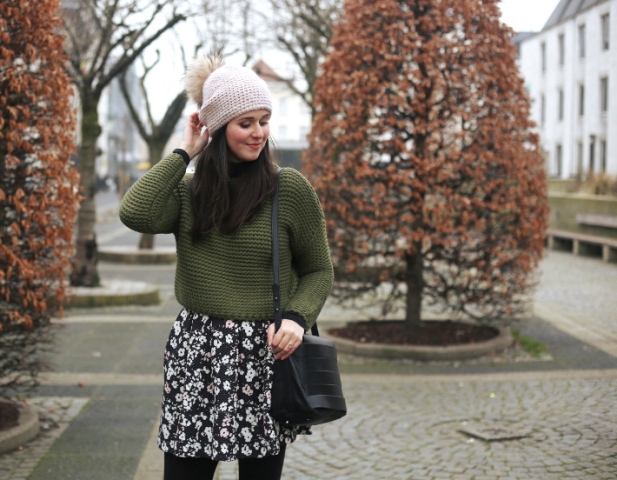 With olive green sweater, floral skirt and black bag