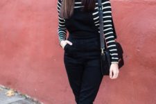 With striped shirt, black jumpsuit, black shoes and leather bag