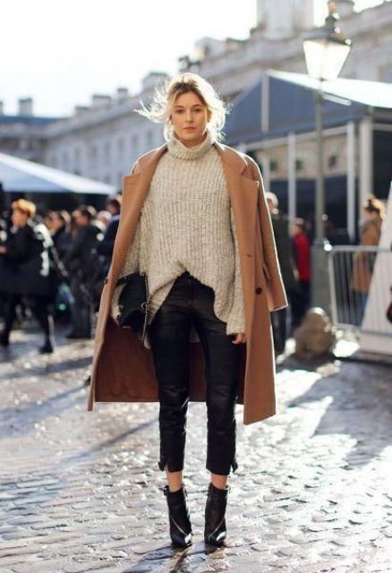 a neutral chunky knit sweater, black cropped leather pants, black booties, a camel coat and a black bag