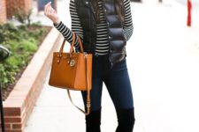 a striped top, navy skinnies, tall black boots, a black puffer vest, a white beanie and an amber bag