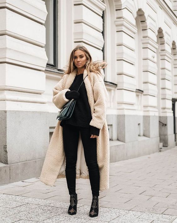 a total black look with a sweater, skinnies, embellished booties and a creamy teddy bear coat