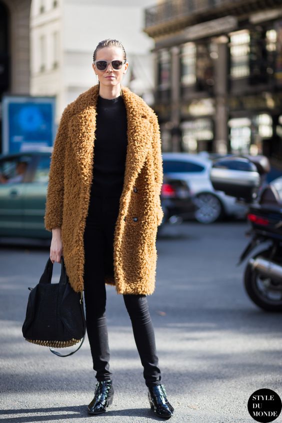 a total black look with skinnies, a long sleeve top, boots and a brown teddy coat