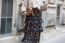 an oversized cable knit neutral sweater, a moody floral midi skirt, rust boots and a neutral bag