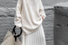 creamy oversized sweater, a creamy pleated midi skirt, black sock boots and a neutral oversized bag