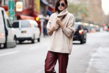 white sneakers, a neutral oversized cashmare sweater, burgundy cropped leather pants