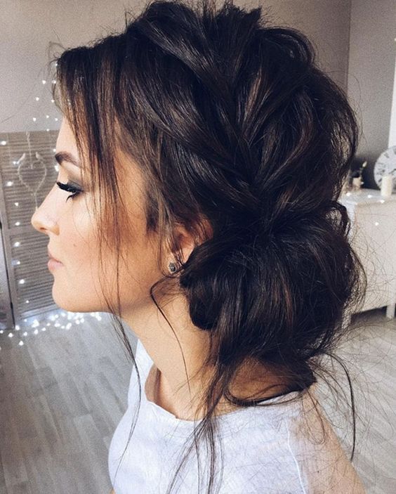 a side braided low bun with some bangs is a super trendy and messy hairstyle to rock