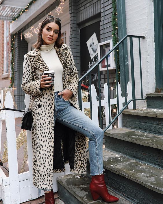 a white turtleneck, blue jeans, red boots, a long leopard coat and a black bag for a touch of chic