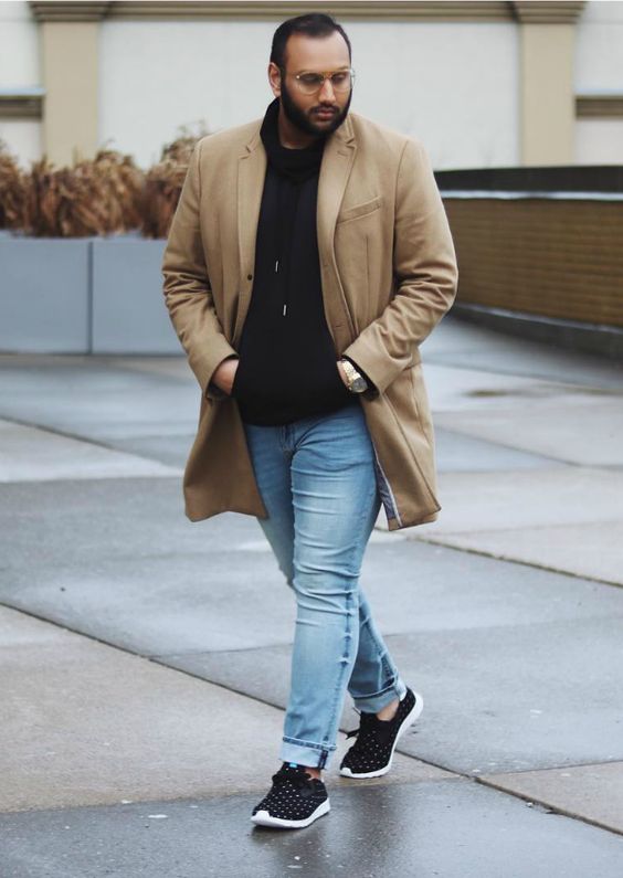 light blue jeans, black trainers, a black hoodie, a camel coat for a simple and casual outfit