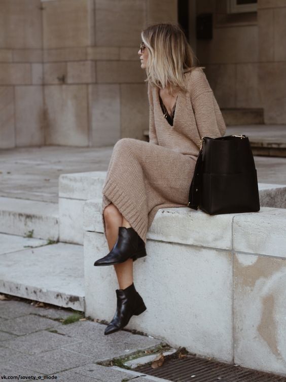 a camel knit midi dress with a black top underneath, black booties and a black bag