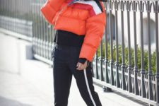16 striped sporty pants, white sneakers, a coral striped cropped puffer jacket for a sport chic winter look