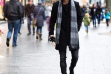 Black shirt, black coat, dark colored jeans and gray striped scarf