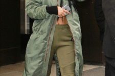 With crop top, olive green sporty pants and green maxi coat