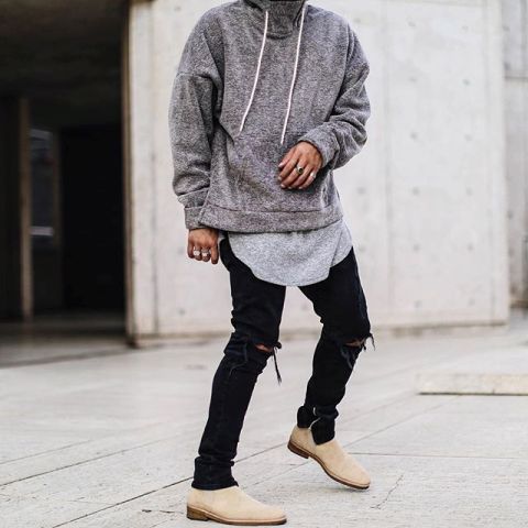 With gray long t-shirt, black distressed pants and beige boots