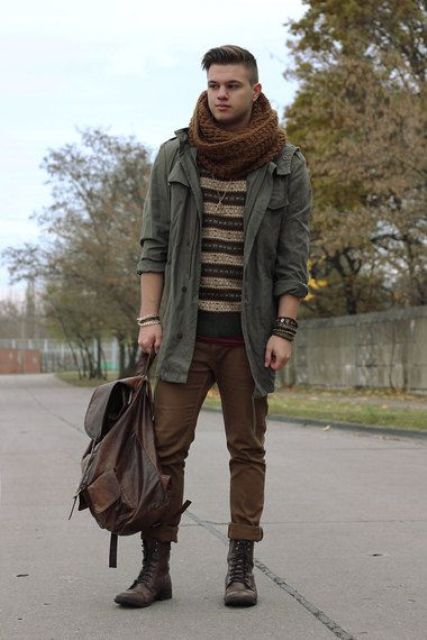 With olive green jacket, brown pants, lace up boots, backpack and knitted scarf