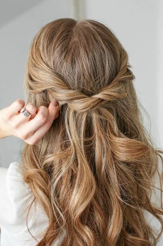 a beautiful half updo with a twisted braid and waves down is a cool idea for a cool look with a slight glam feel
