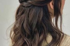 a long hair half updo with a braided top, waves down and a pretty pearly hair pin is a cool and chic idea