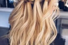 a long wavy half updo hairstyle with a braided halo and locks down for a boho feel