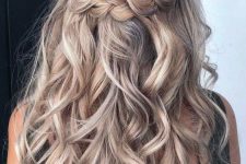 a lovely half updo with a braided halo and waves down is a cool and catchy solution that will work for many occasions