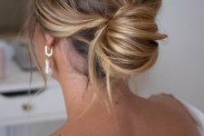 a messy chignon with a messy top and waves down is a chic modern solution for the holidays