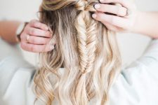 a pretty boho half updo with a bump on top, a fishtail braid and waves down is a cool solution for Christmas