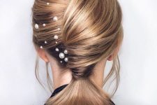a pretty low ponytail with a twisted chignong and pearl hair pins is a cool and unusual solution for medium length hair