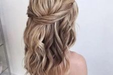 a simple and catchy textured wavy half updo with a twisted halo and a bump on top is a cool and chic idea for any holiday look