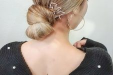 a sleek knotted low bun with a sleek top and a tree-shaped hair pin are a gorgeous combo for a Christmas party