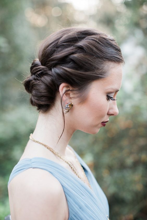 a stylish braided halo updo with a low bun and volume on top is a cool and chic idea for a holiday party