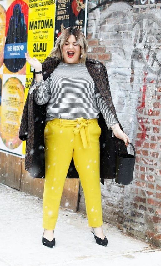 bright yellow pants, a striped top with long sleeves, black shoes and an animal print coat