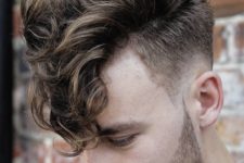 04 a long curly fringe and a low skin fade haircut is a stylish and bold idea