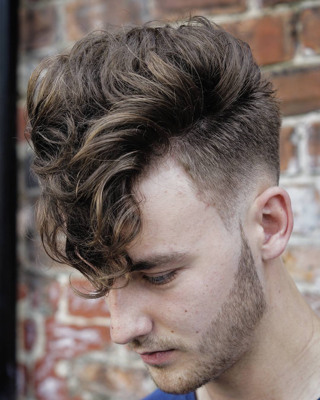 A long curly fringe and a low skin fade haircut is a stylish and bold idea