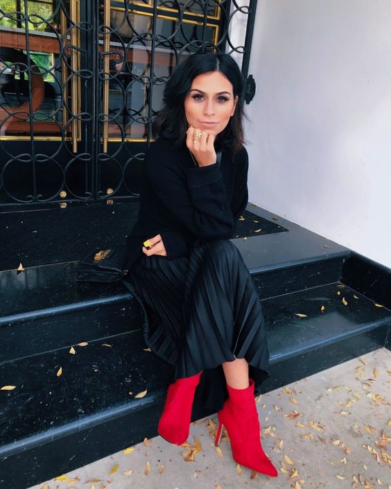 a black top, a black pleated midi and red booties for a bold statement are all you need for an impression